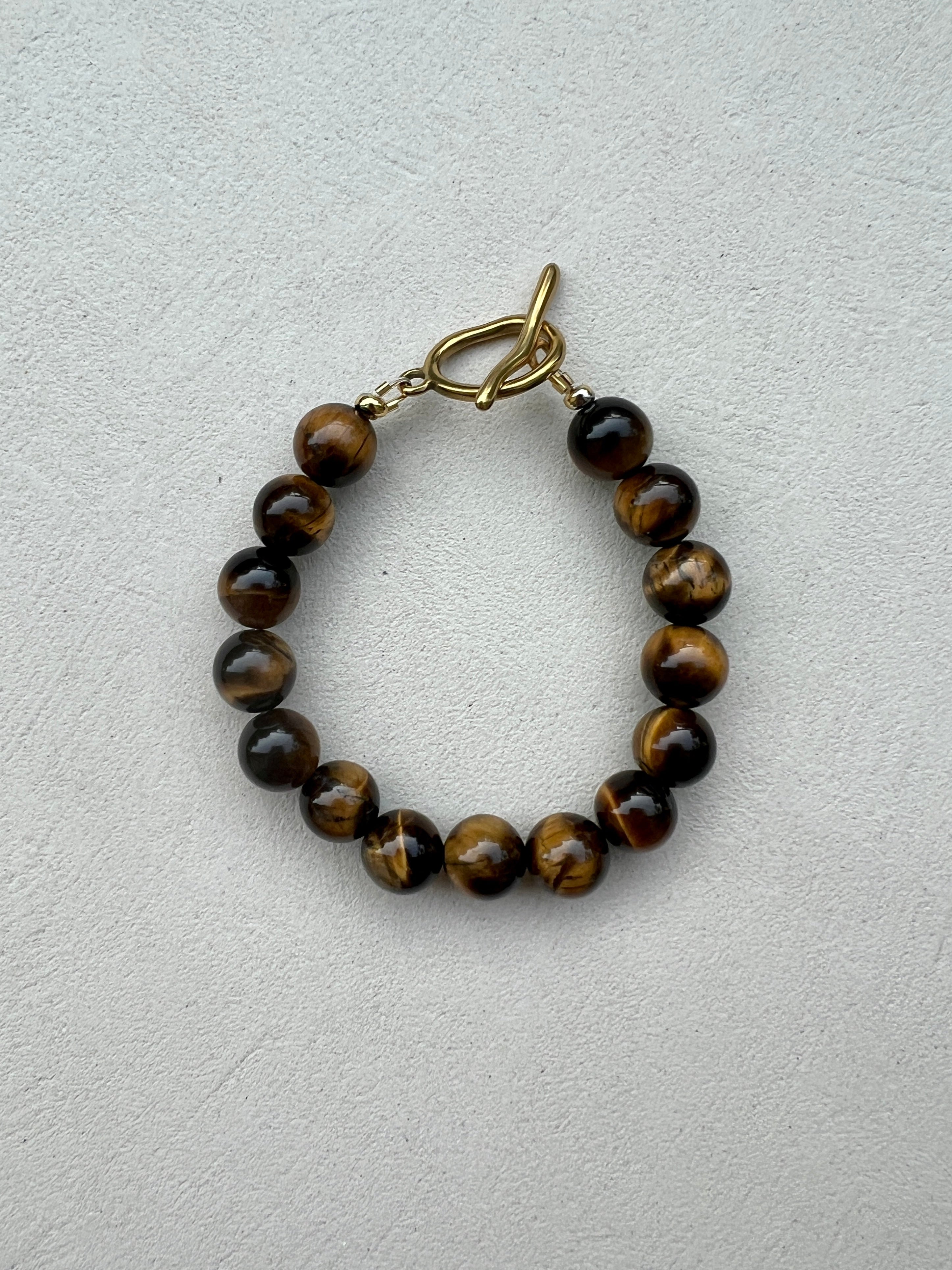 Bracelet with brown beaded design on a light gray background